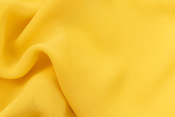 Yellow Silk, satin fabric texture with folds and waves. Textile. Material. Fashion