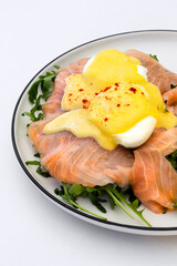 Gourmet Eggs Benedict with Smoked Salmon and Hollandaise Sauce on Arugula