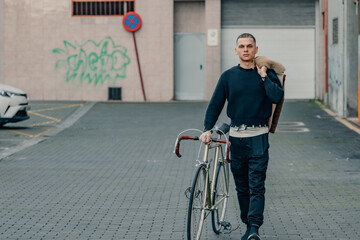 young man with bicycle walking on the street