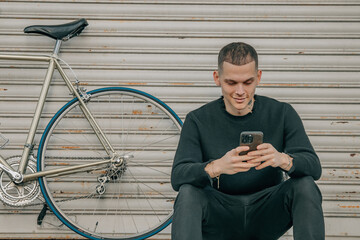 young man sitting on the street with mobile phone