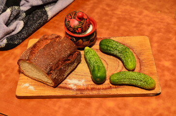 cucumbers on the table and cutting board next to salt shaker on the table light brown next to blanket healthy food