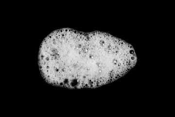 Abstract soap bubbles, shampoo or shaving cream. Isolated soap bubbles on black background with texture and contrast background.