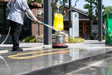 Workers are cleaning the road with a floor scrubber