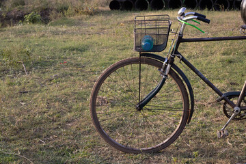 Vintage styles cycle parked in the ground carrying water bottle in the front carrier