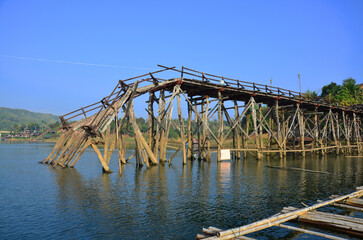 Ancient antique Saphan Mon or Uttamanusorn longest wooden bridge damage broken from flash flood in Songkalia river for thai people traveler travel visit at Sangkhla Buri city in Kanchanaburi, Thailand