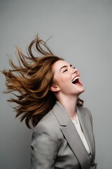 Boss woman in power suit, hair blowing, joyful expression.