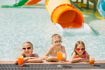 Children drinking cocktails at water park poolside