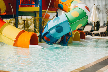 Colorful water slides emptying into refreshing pool at water park