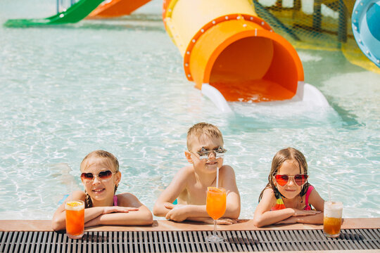 Children drinking cocktails at water park poolside
