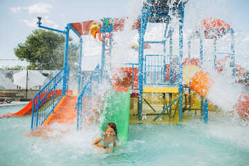 Girl enjoying waterpark slides and spraying water
