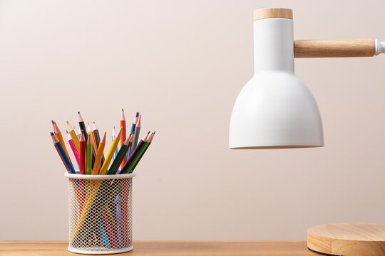 White scandinavian style table lamp and pencils on work desk. Education, study concept background with copy space