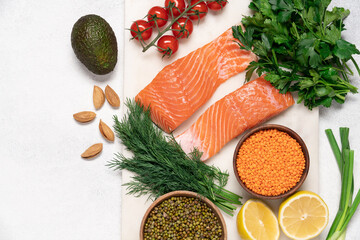 Fresh salmon steaks, beans, tomatoes, green parsley on a light background. Healthy food concept