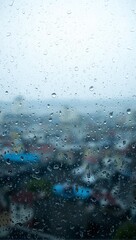 Raindrops on glass with city blur