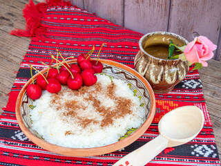 romanian orthodox pentecost dish, rice porridge made with milk and cinnamon icing served in clay pots given in the memory of the lost ones