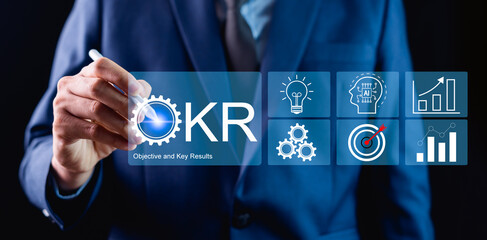 Businessman setting goals and managing tasks for OKR, key objectives and results, measuring results...