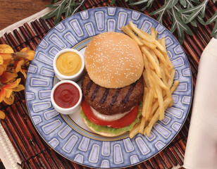 view from above of hamburger potato french fries and sauces dish.