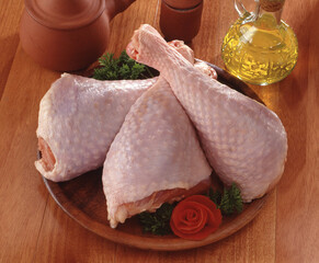 Fresh uncooked raw chicken thighs and ingredients on kitchen table.