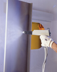 Hand holding Industrial spray paint gun.