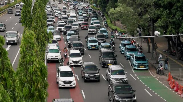 Jakarta, Indonesia - &lrm;May 30, 2025: Heavy traffic fills the streets of Jakarta with cars and motorbikes chaotically on the highway. 4k resolution