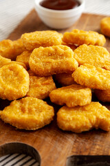 Organic Fried Chicken Nuggets on a wooden board, side view. Close-up.