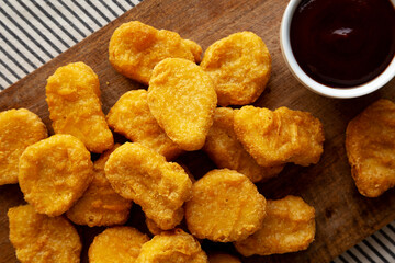 Organic Fried Chicken Nuggets on a wooden board, top view. Close-up.