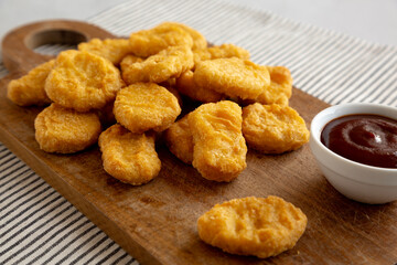 Organic Fried Chicken Nuggets on a wooden board, side view. Close-up.