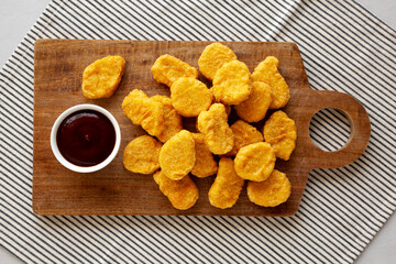 Organic Fried Chicken Nuggets on a wooden board, top view. Overhead, from above.