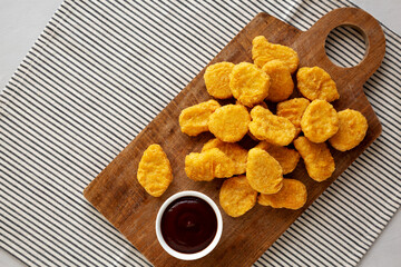 Organic Fried Chicken Nuggets on a wooden board, top view. Copy space.