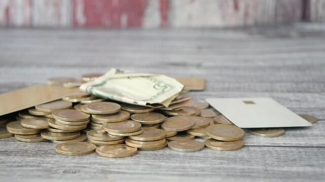 Coins and banknotes scattered on a wooden surface