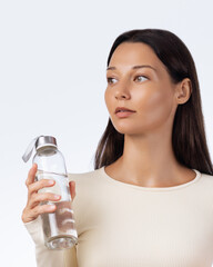 Healthy Woman Holding Water Bottle Looking Away In Studio Wellness Shot