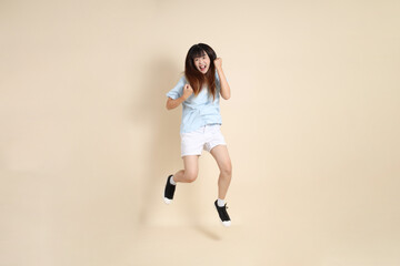 20s Asian Woman in Light Blue Shirt and White Shorts