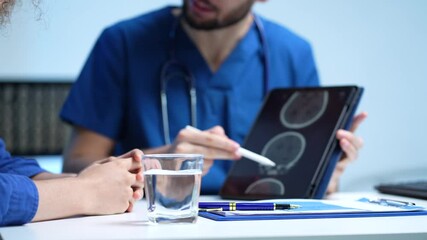 male doctor explaining to patient results of model brain. Diagnosis of diseases and head injuries.