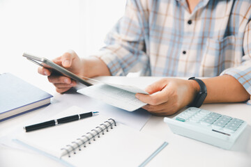 Business hands holding saving account passbook with calculator, account and saving concept. finance effectively, calculate income, track each bill and payment, accounting for bank statements and tax.