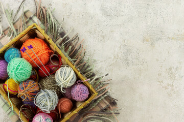Basket with knitting yarn. Multicolored knitting yarn on a textured background. There is space for text.