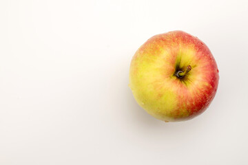 One red apple on a white background, macro, top view.