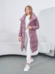Fashion model showcases stylish puffer coat in bright studio setting during photoshoot