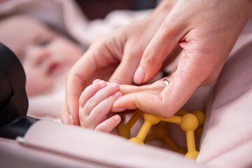 Close-up of a baby gently holding an adult’s finger, symbolizing trust and warmth.