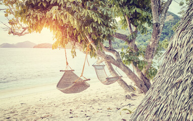 Hammocks on the beach of a tropical island, color toning applied, Philippines.