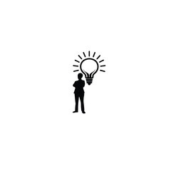 Silhouette of a person standing under a light bulb representing an idea on white background