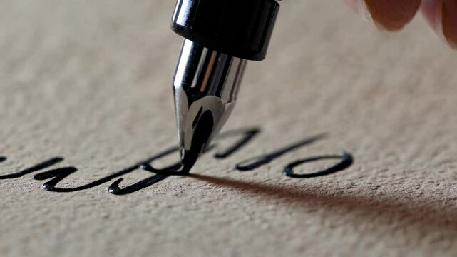 Writing with a fountain pen on textured paper captures the elegance of calligraphy in close detail