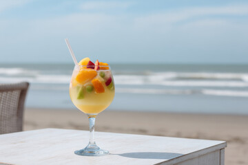 refreshing cocktail named fruit fantasy elegantly placed on white table beside sea