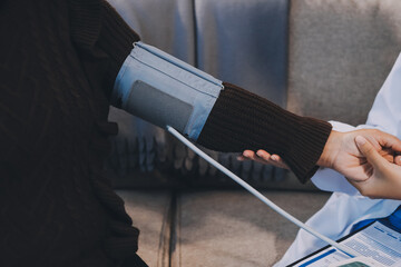 Doctor using Blood pressure monitor and stethoscope checking measuring arterial blood pressure on...
