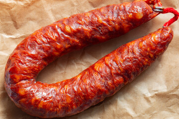 Spanish Chorizo spicy sausage on a brown paper bag background. Environmentally friendly eco biodegradable packaging concept.