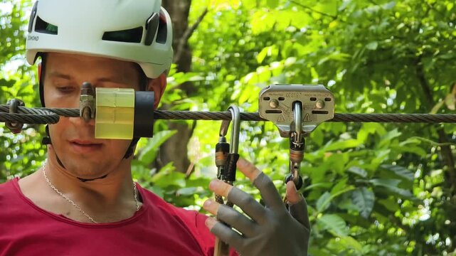 A man is enjoying an exhilarating ride on a zip line that traverses the thick woods surrounding him