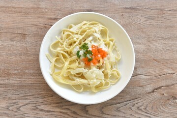 steamed salmon fettuccine alfredo with white cream sauce topping shrimp egg on plate  