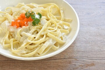 steamed salmon fettuccine alfredo with white cream sauce topping shrimp egg on plate  