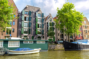 The unique architecture of Amsterdam in summer, showing the unique city buildings and boats along...