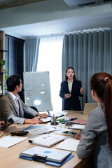 Real Estate Business Plan Presentation by Asian Businesswoman to Team Discussing Market Analysis Property Marketing Strategies and Financial Risks