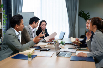 Asian Business Team Meeting in Office Collaboration Brainstorming Planning Strategy and Analyzing Financial Report with Laptop and Documents for Corporate Success
