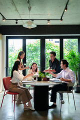 Asian Business Team Enjoying Lunch Together in Modern Office Space Colleagues Sharing Meal Networking During Business Meeting Collaborative Workspace